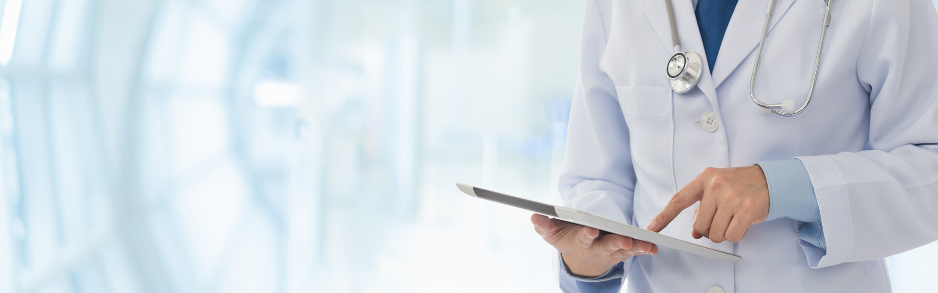 Arzt mit Stetoskop um den Hals und Tablet in der Hand