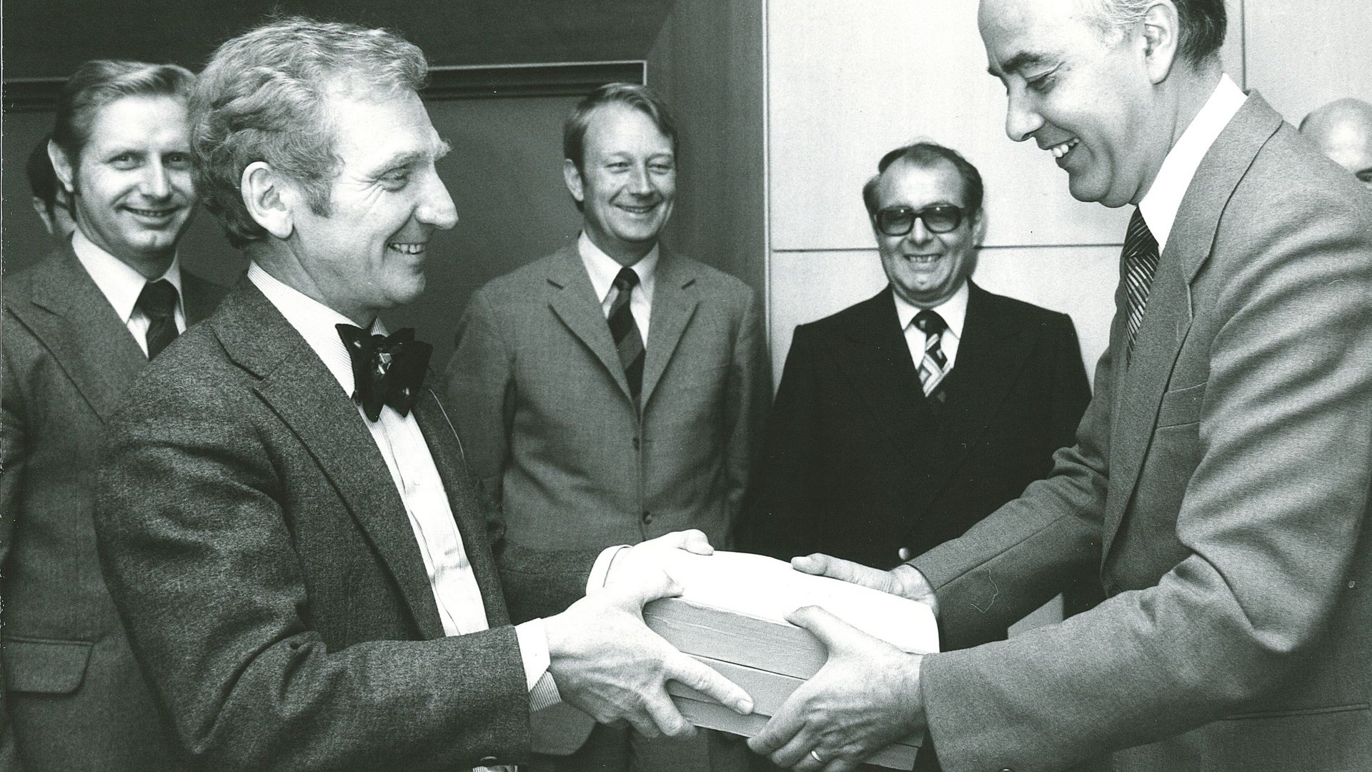 Übergabe des ersten Hauptgutachtens am 22.07.1976 an Bundeswirtschaftsminister Dr. Hans Friderichs in Mainz: v.l.n.r. Josef Murawski, Vorsitzender Ernst-Joachim Mestmäcker, Erhard Kantzenbach, Dieter Fertsch-Röver, Bundeswirtschaftsminister Dr. Hans Friderichs, Dieter Mittelsten Scheid. 