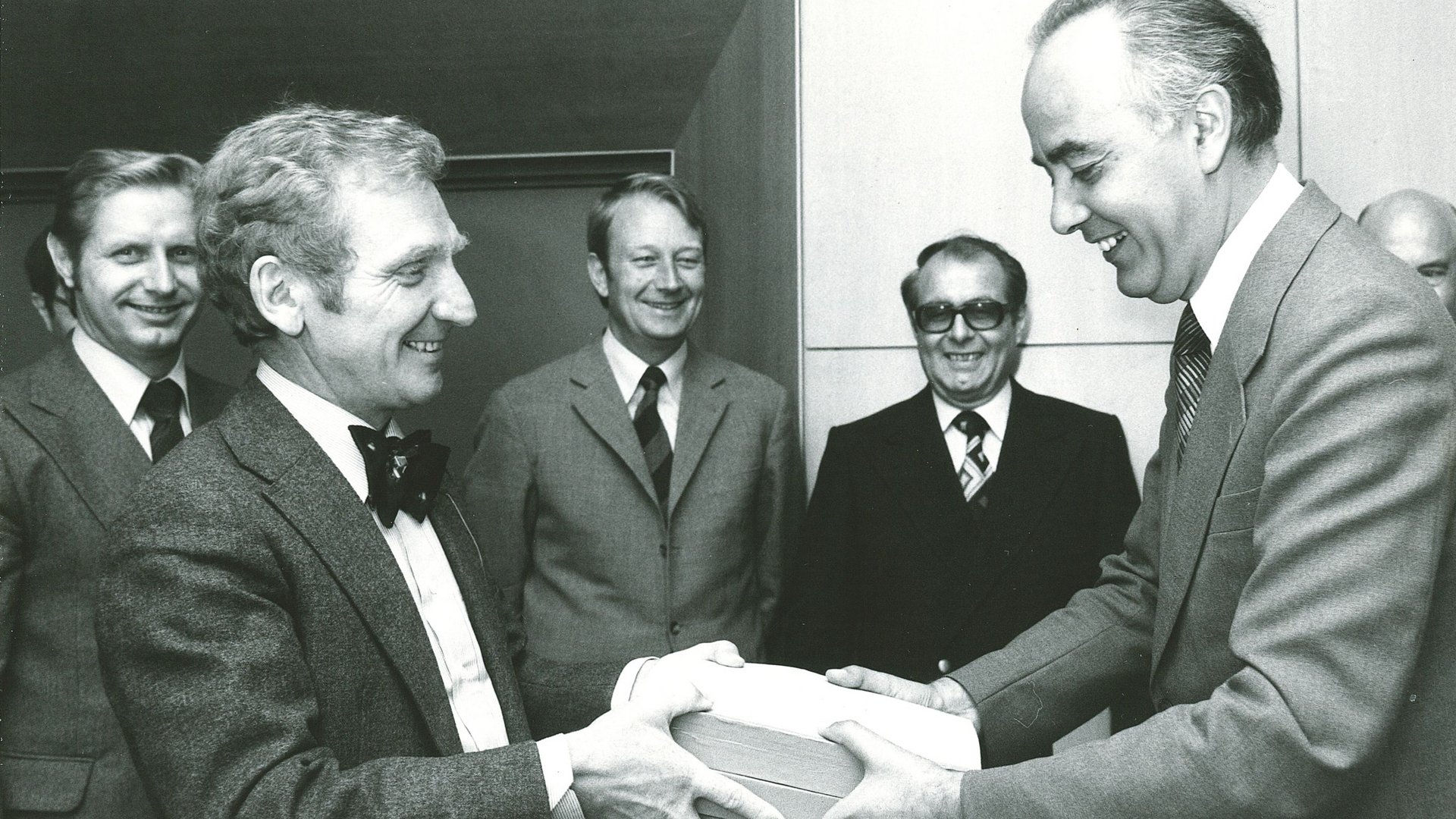 Übergabe des ersten Hauptgutachtens am 22.07.1976 an Bundeswirtschaftsminister Dr. Hans Friderichs in Mainz: v.l.n.r. Josef Murawski, Vorsitzender Ernst-Joachim Mestmäcker, Erhard Kantzenbach, Dieter Fertsch-Röver, Bundeswirtschaftsminister Dr. Hans Friderichs, Dieter Mittelsten Scheid. 