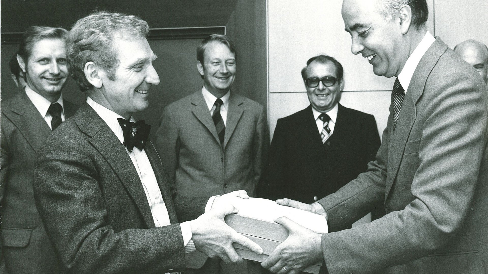 Übergabe des ersten Hauptgutachtens am 22.07.1976 an Bundeswirtschaftsminister Dr. Hans Friderichs in Mainz: v.l.n.r. Josef Murawski, Vorsitzender Ernst-Joachim Mestmäcker, Erhard Kantzenbach, Dieter Fertsch-Röver, Bundeswirtschaftsminister Dr. Hans Friderichs, Dieter Mittelsten Scheid. 