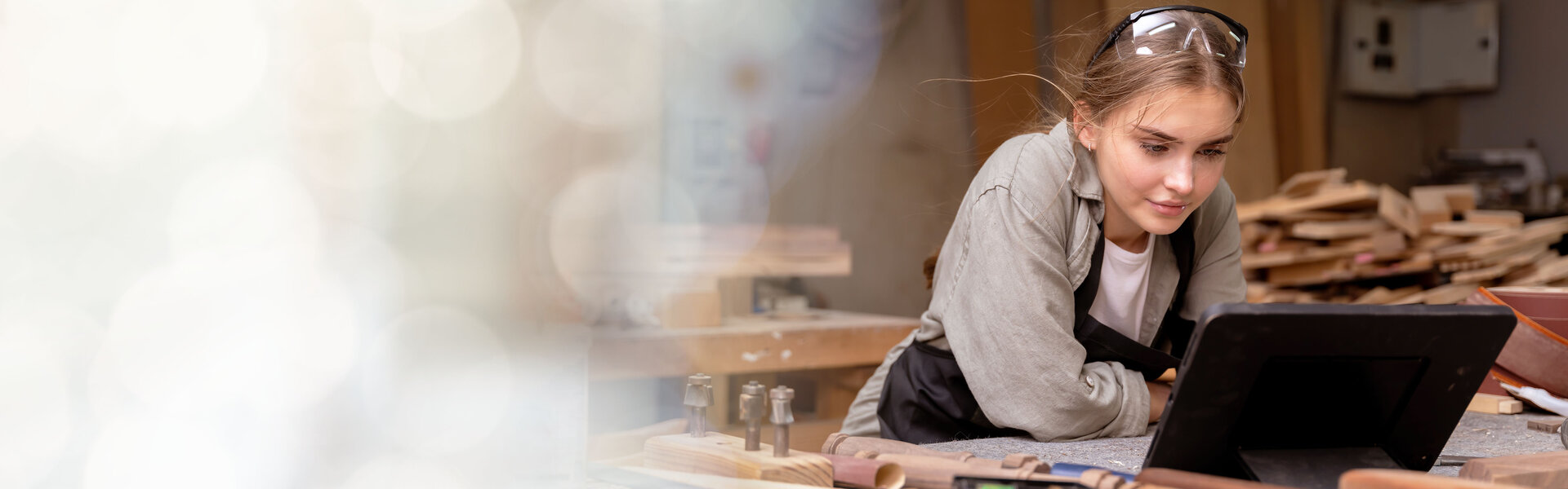 Handwerkerin in einer Schreinerei vor ihrem Laptop