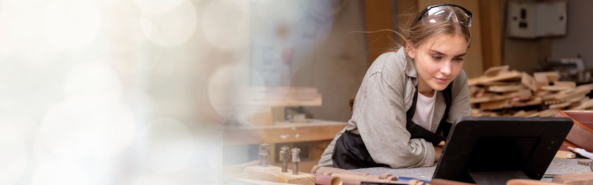 Handwerkerin in einer Schreinerei vor ihrem Laptop